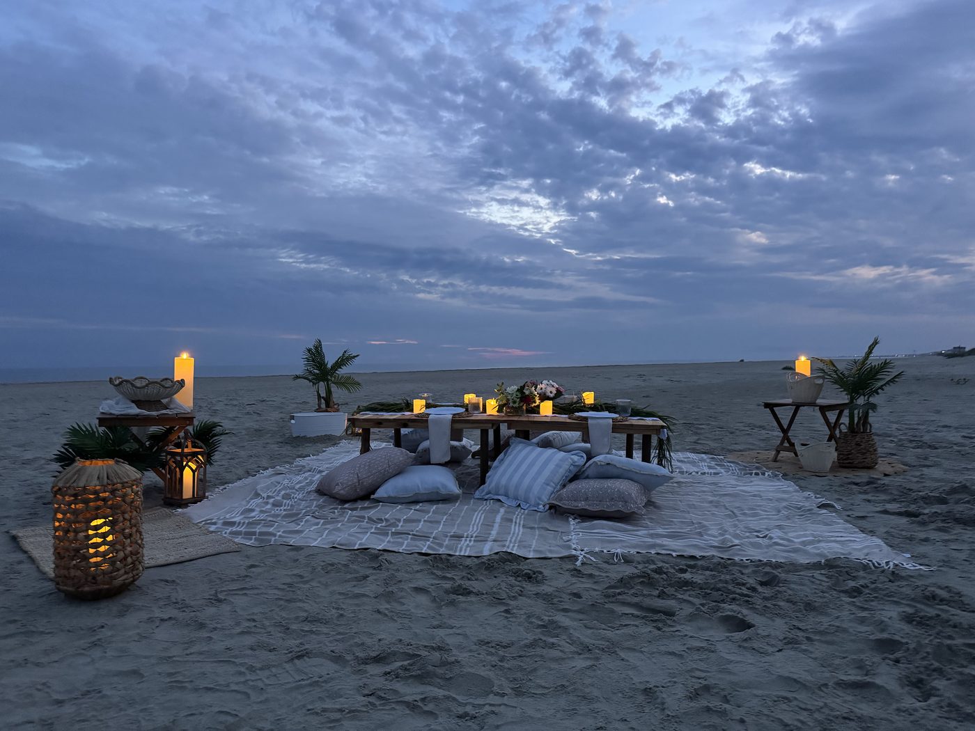 Twilight beach table setup with candles and florals